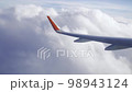 Flying in a plane through the fluffy, snow-white clouds. Spectacular view from the window of an airplane. 98943124