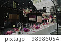 Wedding table served outside and decorated with chandeliers, candles, and colourful flowers for wedding dinner.  Wedding table served outside and decorated with chandeliers, candles, and colourful flowers for wedding dinner.  98986054