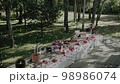 Decorated wedding table with bright flowers in the wood Decorated wedding table with bright flowers in the wood 98986074