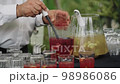 Close up waiter pouring punch into glasses Close up waiter pouring punch into glasses 98986086