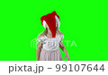Playful 5 years old girl child playing with Christmas Santa hat. Chroma key green screen background 99107644