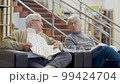 Elderly Caucasian men sitting in library and talking 99424704