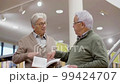 Senior gray-haired friends discussing book in public library 99424707