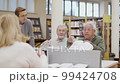 Senior people disputing with each other during class in library 99424708
