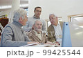 Senior men and teacher looking laptop screen in library 99425544