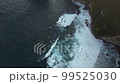 Top down view of ocean cliff covered with greenery. White foam with turquoise clear water in waves rushes to shore on cloudy day on the island of Nusa Penida in Indonesia. Travel concept. Drone view 99525030