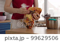 A young girl cooks in a spacious kitchen 99629506