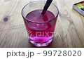 A hand dips a brush with pink paint into a glass. In the video, a hand dunks a brush with pink paint into a glass. 99728020