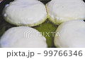 Pies are fried in frying pan in oil. Fast food preparation. Fried food. 99766346