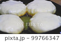 Pies are fried in frying pan in oil. Fast food preparation. Fried food. 99766347