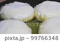 Pies are fried in frying pan in oil. Fast food preparation. Fried food. 99766348