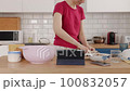 A young girl cooks in a spacious kitchen 100832057