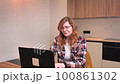 woman in the kitchen working on a laptop. girl communicates remotely on work issues 100861302