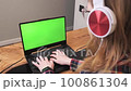 Shot over the shoulder of a woman working remotely from home at the computer 100861304