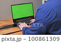 side view of a man behind a laptop. Over shoulder view of white male businessman and laptop with green screen 100861309