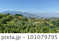 A view of a small village on the top of a hill with the Himalayan Mountains in the background with a panning view. 101079795