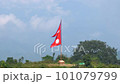 A view of a big Nepal Flag on the top of a hill blowing in the wind.  101079799