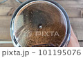 Coffee beans are ground in a coffee grinder. In the video, coffee beans are ground in a coffee grinder with a transparent lid, close-up. 101195076