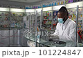 Experience professional healthcare assistance as a male black pharmacist wearing a protective face mask assists a female customer in buying prescription drugs in drugstore. 4K high-quality footage 101224847