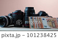 Photographic camera lenses alongside money banknotes in moder beige studio  101238425