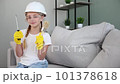 A child in construction overalls. Construction of houses. Home renovation. 101378618