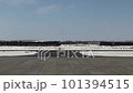 残雪の残る早春のとかち帯広空港の滑走路を航空機が通過する 101394515