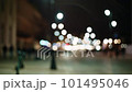 Bokeh city life, cityscape blurred background, urban street illuminated in evening. People pedestrians walking in slow motion. Downtown cityscape, night illumination, rainy weather 101495046