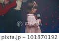 Little girl on stage in vintage dress, she sings into microphone and dances, her father plays acoustic guitar. Color music is shining and smoke is billowing. Father and Child Day, performance on stage 101870192
