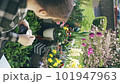 Woman holding cup of coffee on her green balcony 101947963
