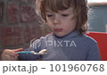 a little boy is interestedly looking at the tablet and eats yogurt 101960768