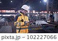 A male process engineer works on a personal computer. Portrait of a professional heavy industry engineer. Building under construction. Safety glasses and hard hat. FullHD slow motion 102227066