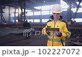 A male process engineer works on a personal computer. Portrait of a professional heavy industry engineer. Building under construction. Safety glasses and hard hat. FullHD slow motion 102227072
