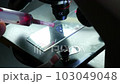 Close-up shot scientific laboratory microscope examining a drop of blood virus on a prepared sample slide. Education, science or medicine industry 103049048
