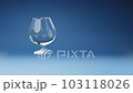 Brandy and Cognac Glass Spinning on Studio Blue Background 103118026