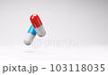 Red and Blue Pills Spinning on Studio Light Gray Background 103118035
