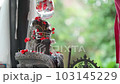 A man performs a ritual in front of the altar with the Hindu god Lord Shiva Lingam, sprinkles flowers. 103145229