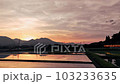 A yellow train running in the reflection of the sunset in the paddy fields 103233635
