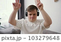 A guy with down syndrome having great time on the living room at home listening music 103279648