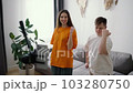 Downs Syndrome guy dancing in front mobile camera at home with a smiling girl in pair, slow motion 103280750