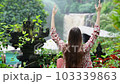 a young girl meditates in nature, sitting in a lotus position near a waterfall, medicine yoga asana kundalini energy balance daily routine practice is good for women's health 103339863