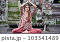 a young girl meditates near a Buddhist temple, the flight of a butterfly as a symbol of the rebirth of the soul 103341489