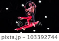 Circus aerial hoop duo on black background performing risky tricks. Man and women fly on stage 103392744