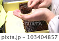 Japanese confectionery craftsman stuffing bean paste in monaka 103404857