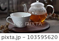 從玻璃茶壺中將路易波士茶倒入杯子中 103595620