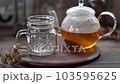 從玻璃茶壺中將路易波士茶倒入杯子中 103595625