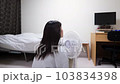 夏の暑い日に部屋で扇風機の風にあたって涼む若い女性の後ろ姿の動画素材 [103834398]