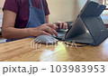 Female baker hand typing on laptop computer keyboard. 103983953
