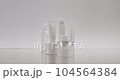 White Bottle and tubes for cosmetics on a white background in studio, camera zoom in. Natural cosmetics production for hair and skin care. Glossy cosmetic jar with cream. 104564384