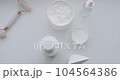 Natural cosmetics, skin care products. Bottle with pipette with gel, fluid, collagen serum, oil, cream, lotion on a white background. Bottles with cosmetic products and sponges for skincare massage. 104564386