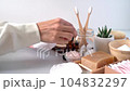 Natural bathroom and home spa tools. Zero waste sustainable concept. Woman hands drop in homemade DIY beauty products in reusable bottles on white background. Bamboo toothbrush, soap bar, cotton pads. 104832297